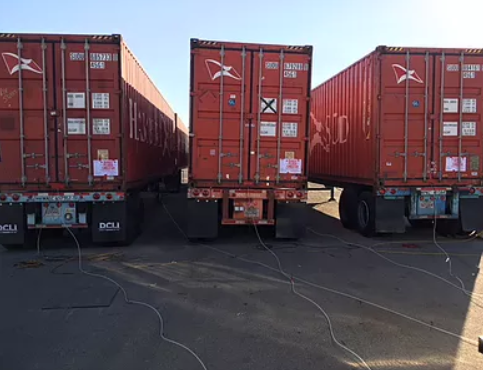 Shipping containers on chassis with fumigation hoses